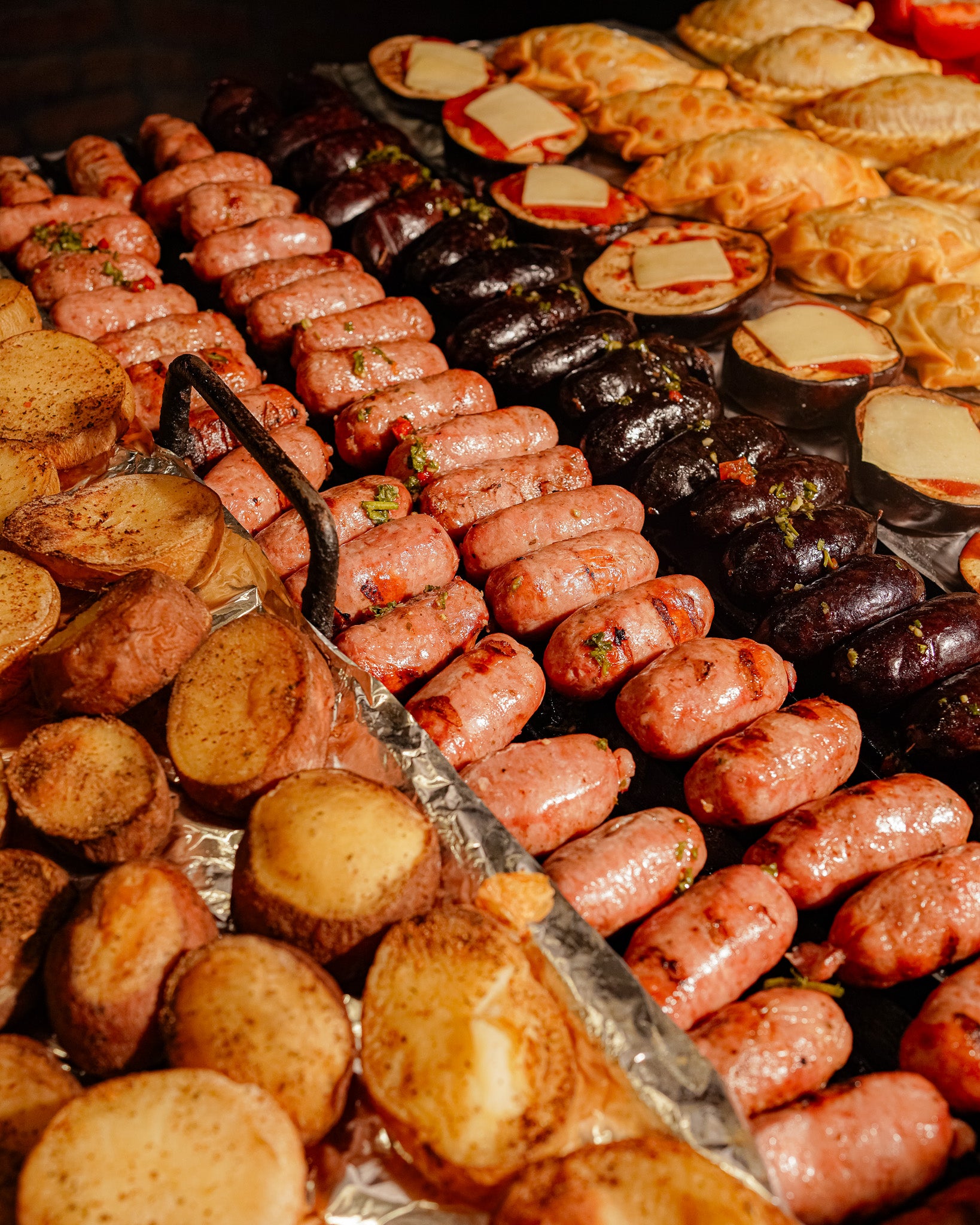 Homemade chorizo and blood sausage sizzling on the grill