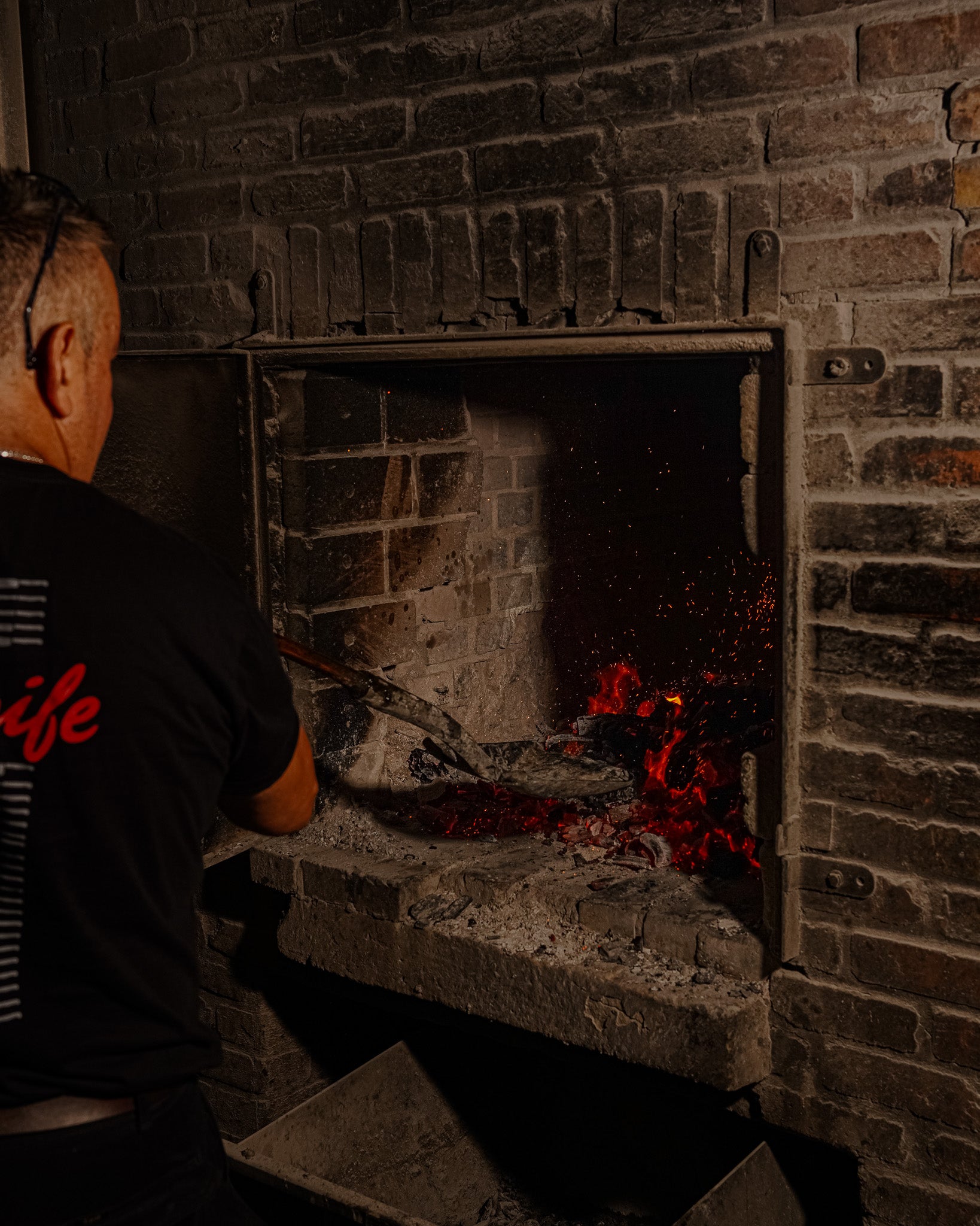 Llamas elevándose desde la parrilla durante el asado argentino